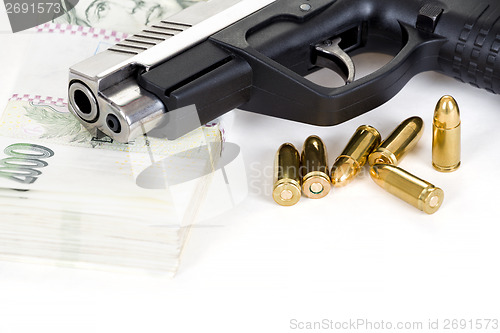 Image of gun with bullet and czech banknotes