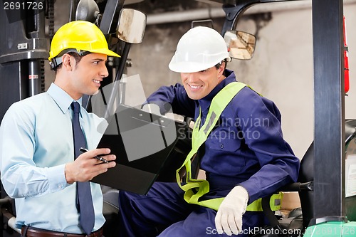 Image of Supervisor Showing Clipboard To Forklift Driver