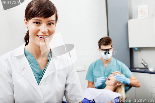 Image of Female Assistant With Dentist Working In The Background
