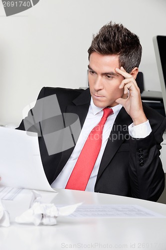 Image of Thoughtful Businessman Working At Desk