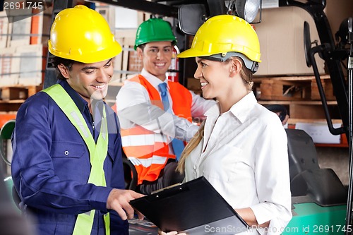 Image of Supervisor Communicating With Foreman At Warehouse