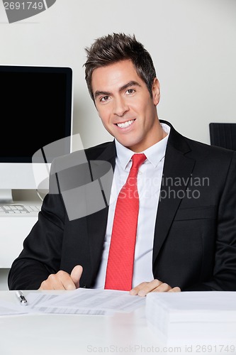 Image of Happy Businessman Sitting At Desk