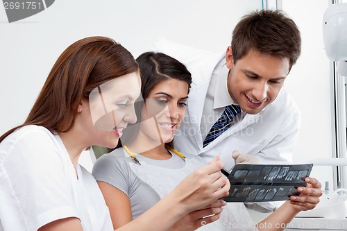 Image of Female Nurse And Dentist Explaining X-Ray Report To Patient