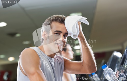 Image of Man Wiping Sweat With Towel At Health Club