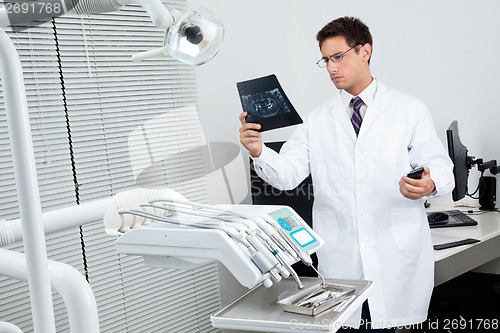 Image of Dentist Analyzing X-Ray Report
