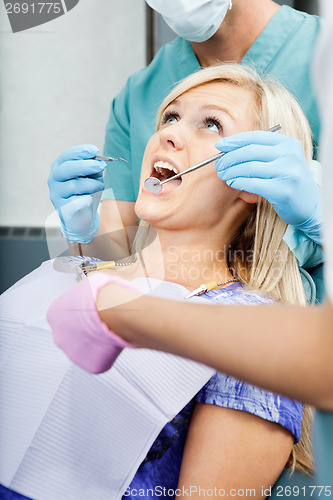 Image of Dentists Treating A Female Patient At Clinic