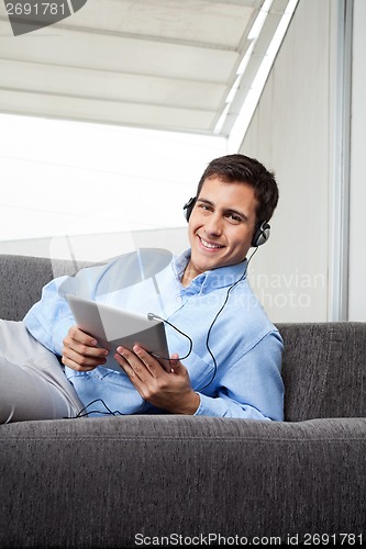 Image of Man Listening Music On Digital Tablet