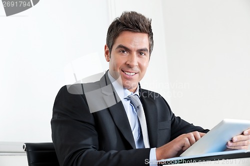 Image of Young Businessman Using Digital Tablet In Office
