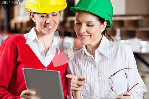 Image of Female Supervisors Using Digital Tablet At Warehouse