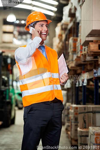 Image of Supervisor Using Cell Phone At Warehouse