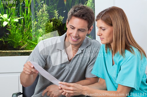 Image of Dentist And Patient Reading Report