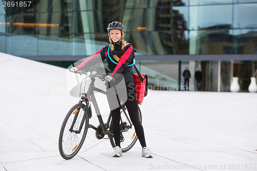 Image of Female Cyclist With Courier Delivery Bag