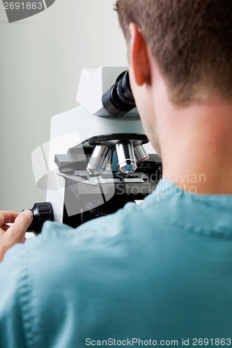 Image of Male Researcher Using Microscope In Laboratory