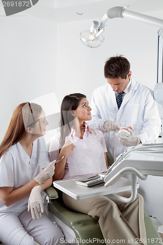 Image of Dentist Explaining Teeth Model To Patient In Clinic