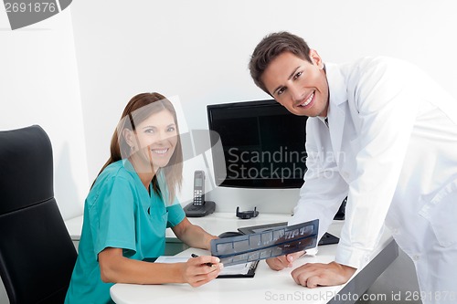 Image of Happy Dentist And Assistant With X-Ray Report