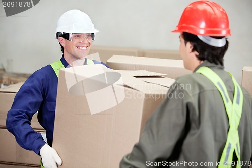 Image of Foremen Carrying Cardboard Box At Warehouse