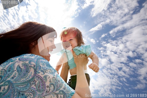 Image of Mother Holding Daughter in Air