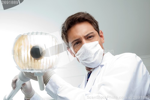 Image of Dentist Holding Dental Lamp