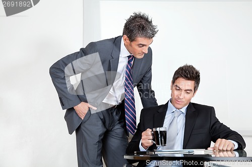Image of Businessman With Coffee Cup In A Meeting With Colleague