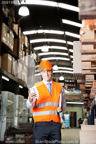 Image of Male Supervisor Using Cell Phone At Warehouse