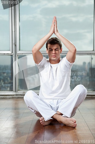 Image of Young Man Practicing Yoga At Gym