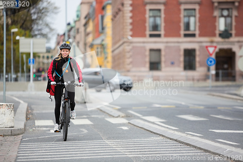 Image of Female Cyclist With Courier Delivery Bag On Street