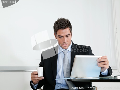 Image of Businessman With Coffee Cup Using Digital Tablet