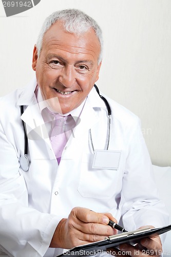 Image of Doctor Writing On Clipboard