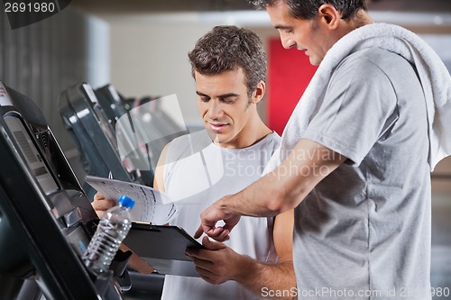 Image of Instructor Guiding Man To Fill The Membership Form