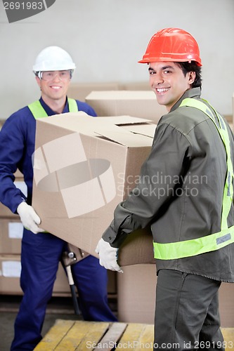 Image of Foremen Lifting Cardboard Box in Warehouse