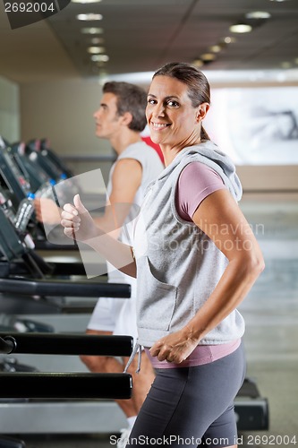 Image of Woman And Man Running On Treadmill