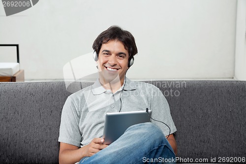 Image of Man Listening Music On Tablet PC