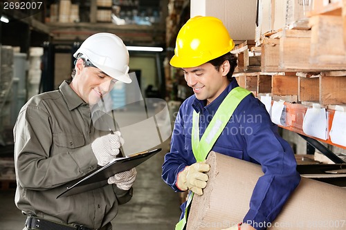 Image of Foreman Looking At Supervisor Writing Notes