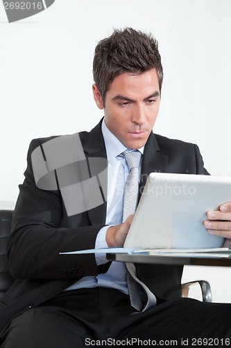 Image of Young Businessman Using Digital Tablet In Office