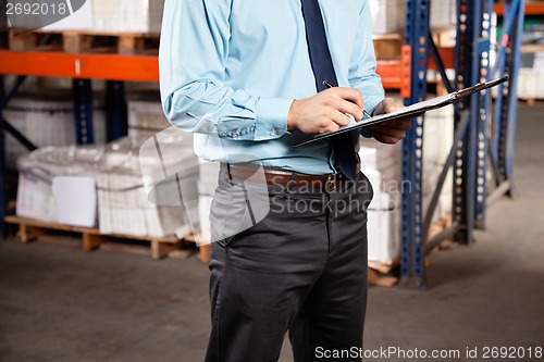 Image of Supervisor Writing On Clipboard At Warehouse