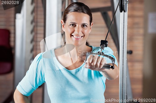 Image of Happy Woman Working Out In Health Club