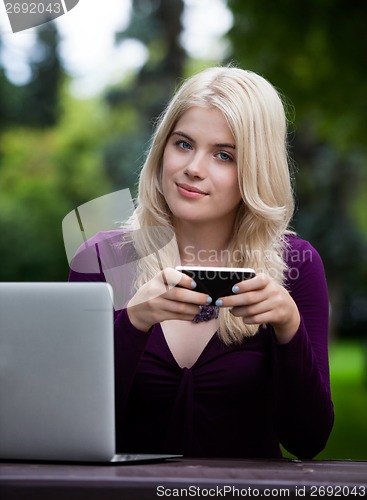 Image of Beautiful Woman in Park with Smart Phone