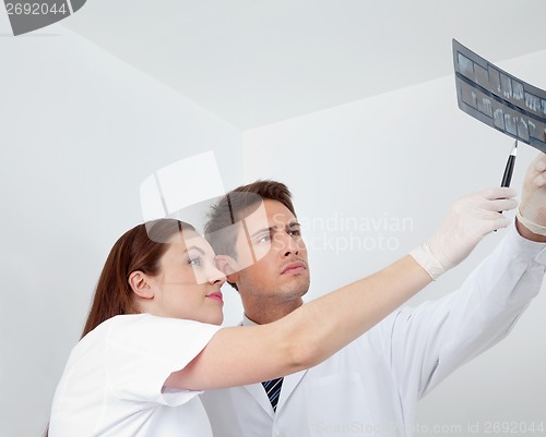 Image of Doctor And Assistant Analyzing Patient's Report