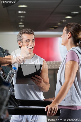 Image of Happy Instructor Looking At Client Exercising On Treadmill