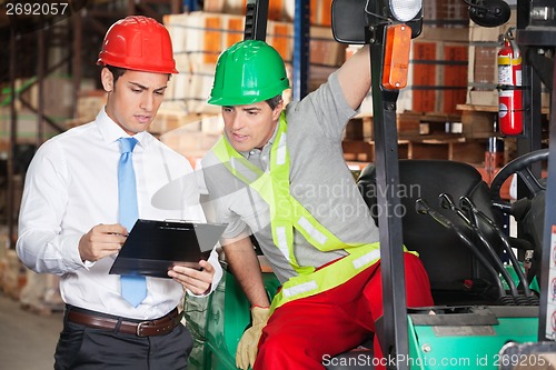 Image of Supervisor Showing Clipboard To Forklift Driver