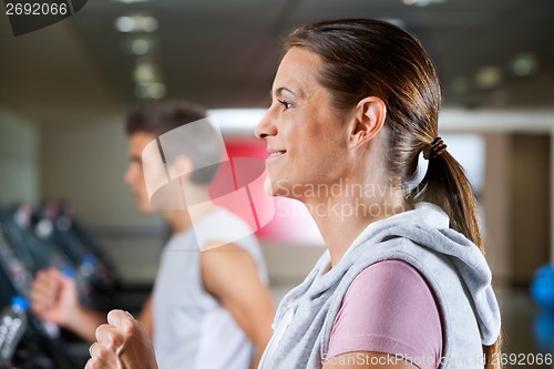 Image of Woman And Man Running On Treadmill