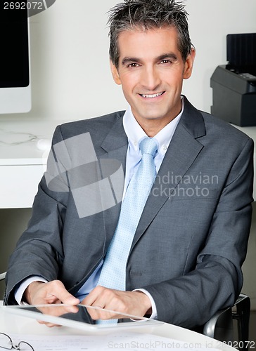 Image of Businessman With Digital Tablet Sitting At Desk