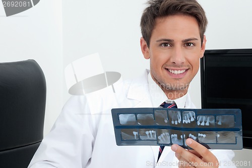 Image of Male Dentist Holding X-Ray Report