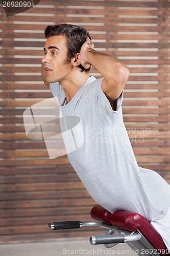 Image of Man Exercising On Machine In Health Club