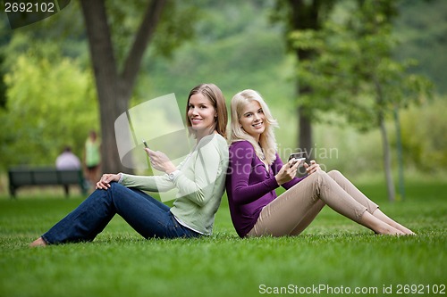 Image of Female Friends With Cellphones In Park