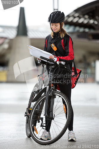 Image of Female Cyclist With Courier Bag And Package On Street