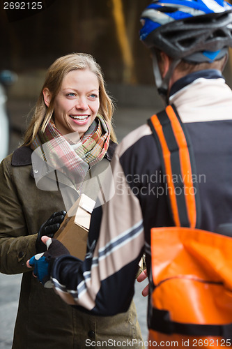 Image of Smiling Young Woman Receiving A Package From Courier Delivery Ma