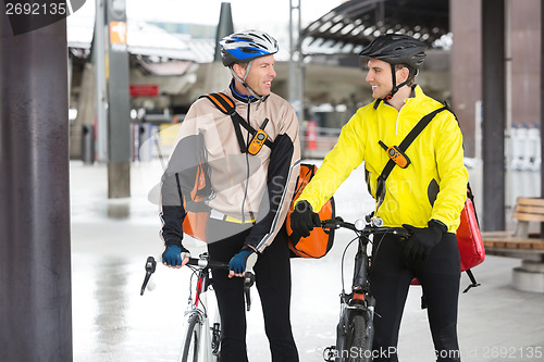 Image of Courier Delivery Men With Bicycles Looking At Each Other