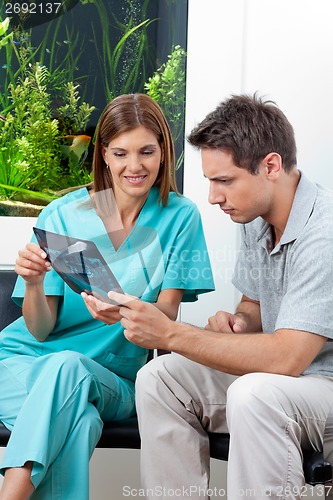 Image of Dentist Showing X-Ray Report To Patient