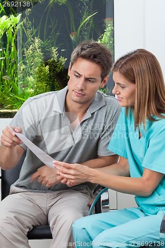 Image of Dentist And Patient Reading Report